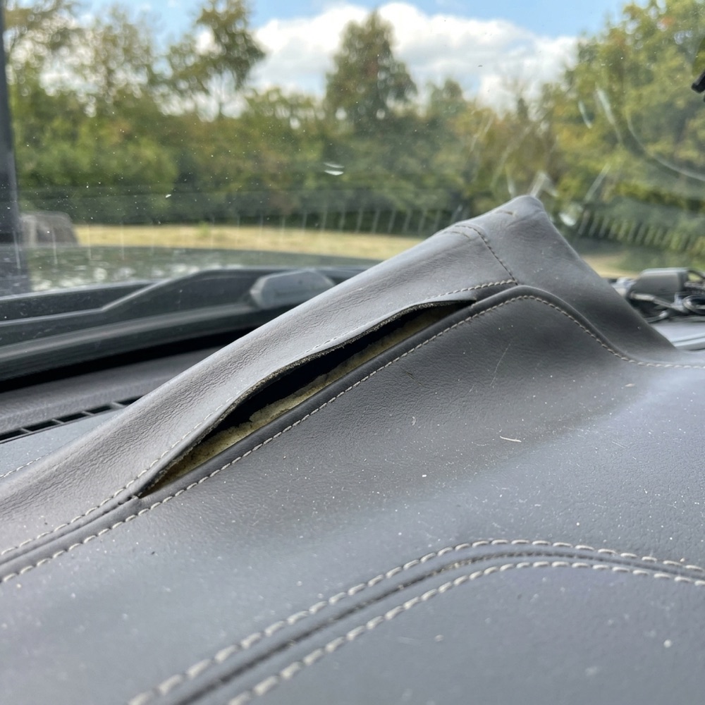 The leather over the gauges pulled away at its edge, with a gap underneath