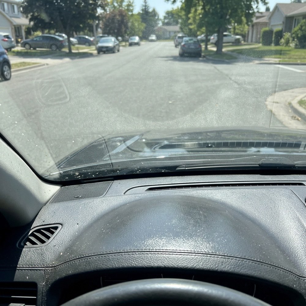 A glossy dashboard top reflecting in the windshield