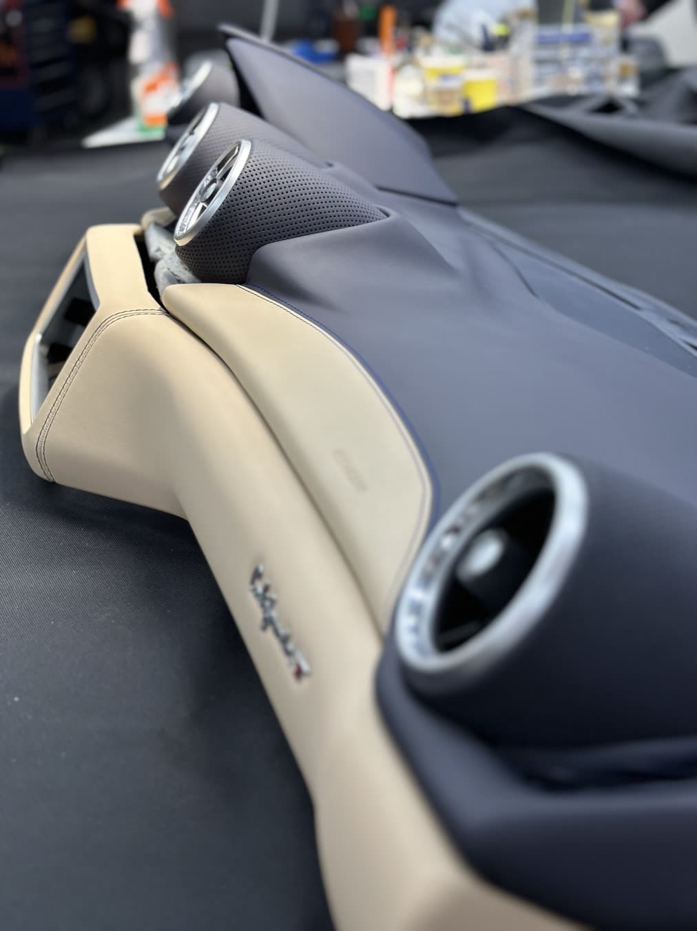 A two-tone dashboard in beige and navy leather with round air vents