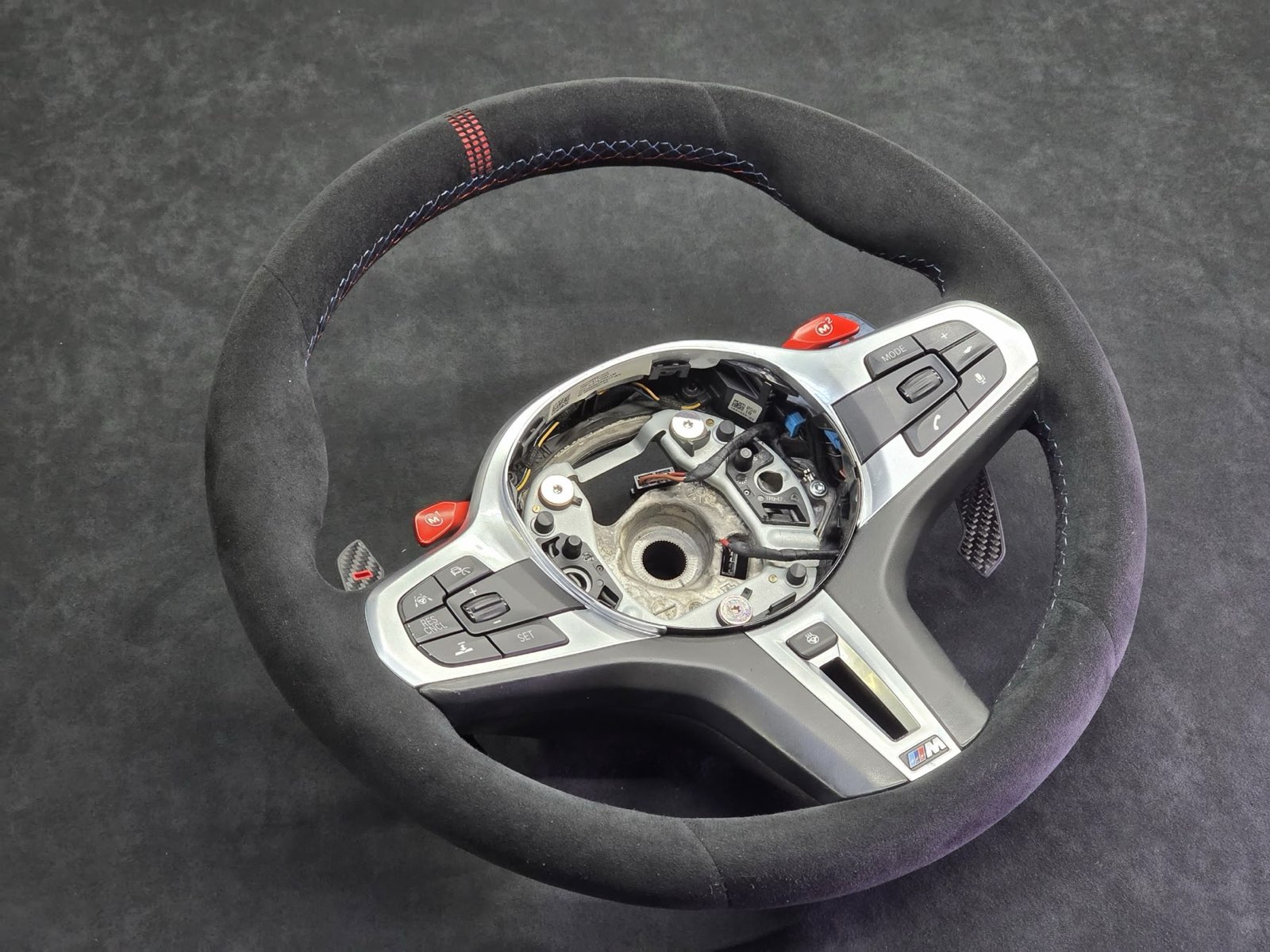 A BMW M steering wheel in black Alcantara with red stitching