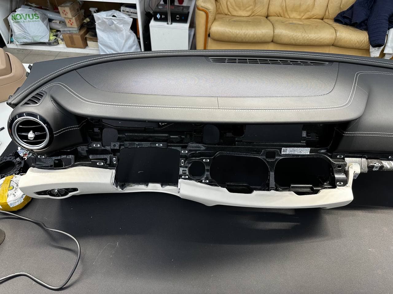 A whole dashboard in black leather on the bench before it goes back in the car