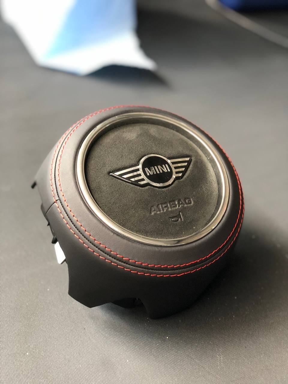 A MINI airbag cover in black leather with red stitching