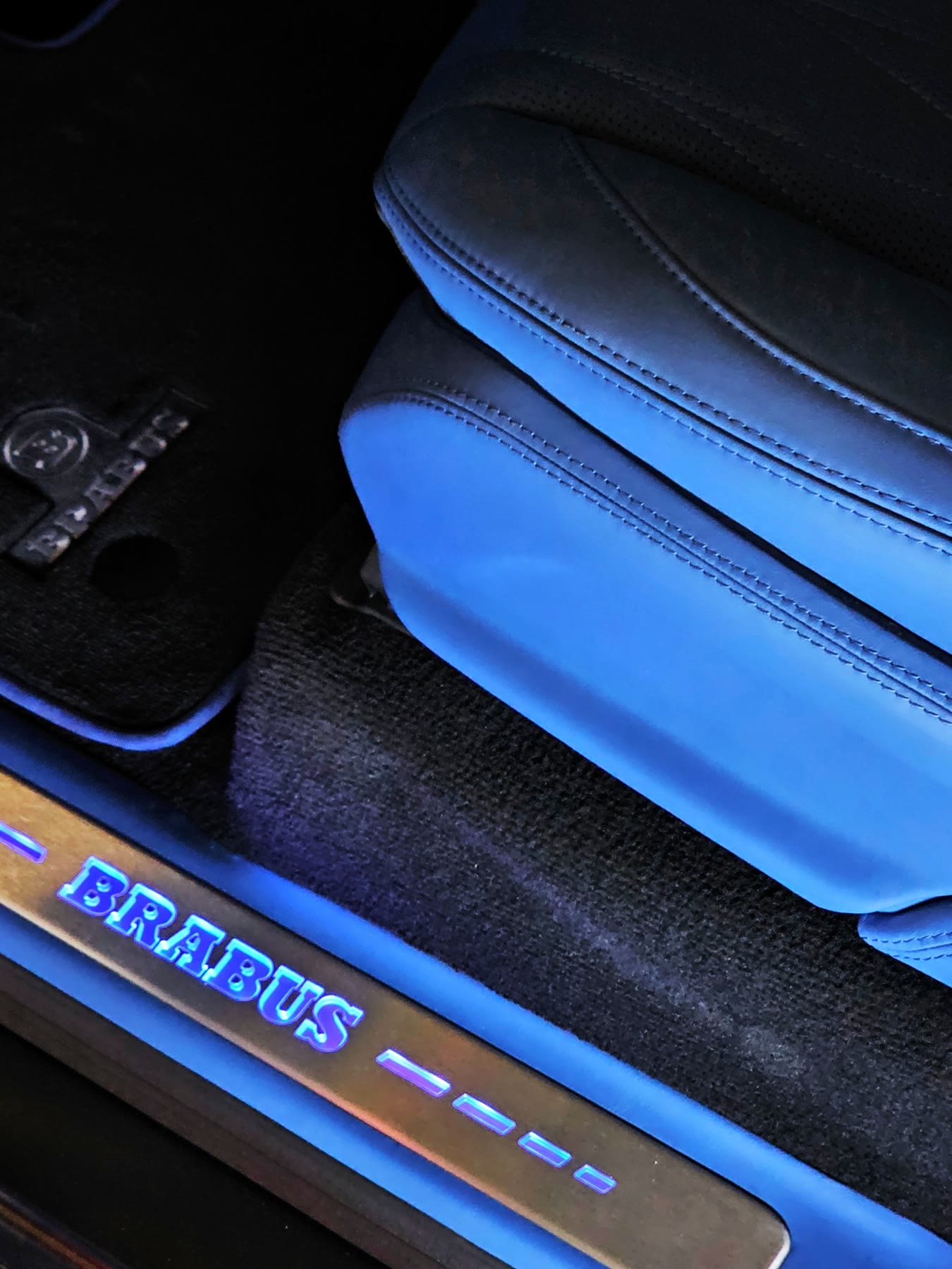 A G-Wagon front seat in blue leather above a lit Brabus sill