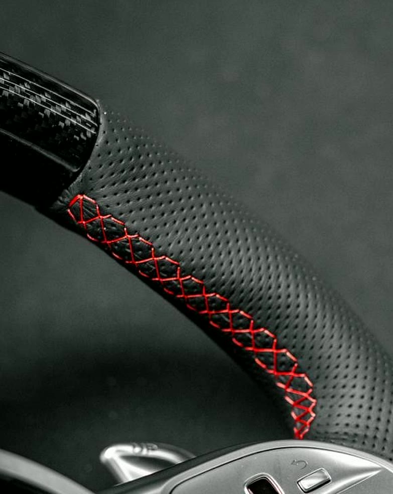 Red cross stitch on a perforated leather wheel, every cross the same size.