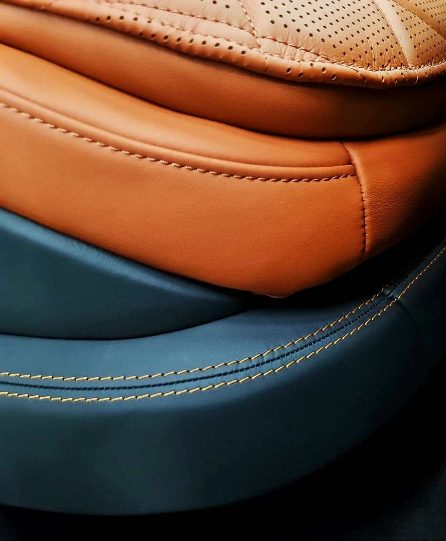 Tan and teal leather joined with a yellow stitch.