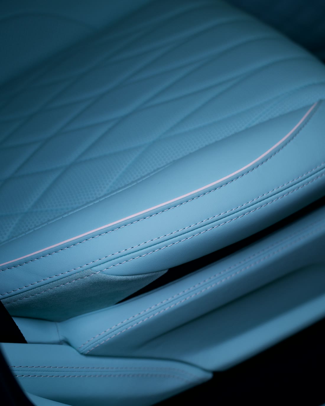 Soft quilting and a contrast piping on a turquoise seat.