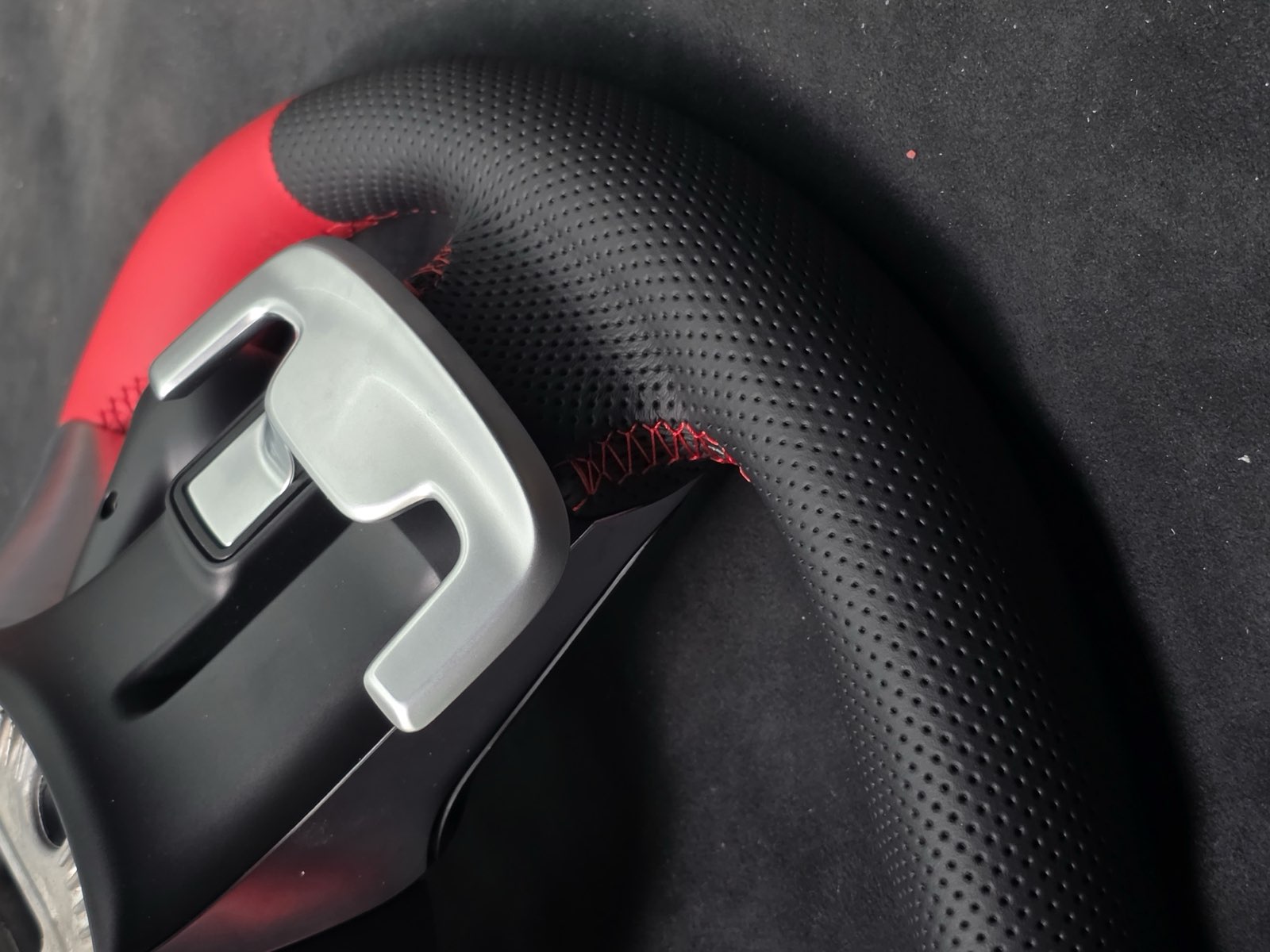A black perforated grip next to the red leather