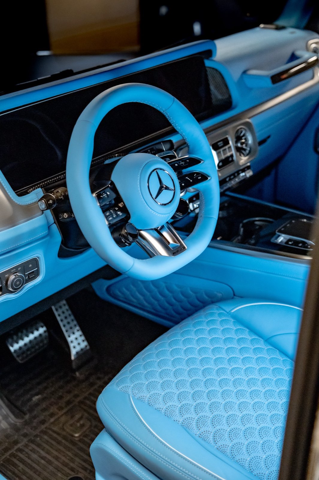 A G-Wagon cockpit with a sky blue steering wheel and seats