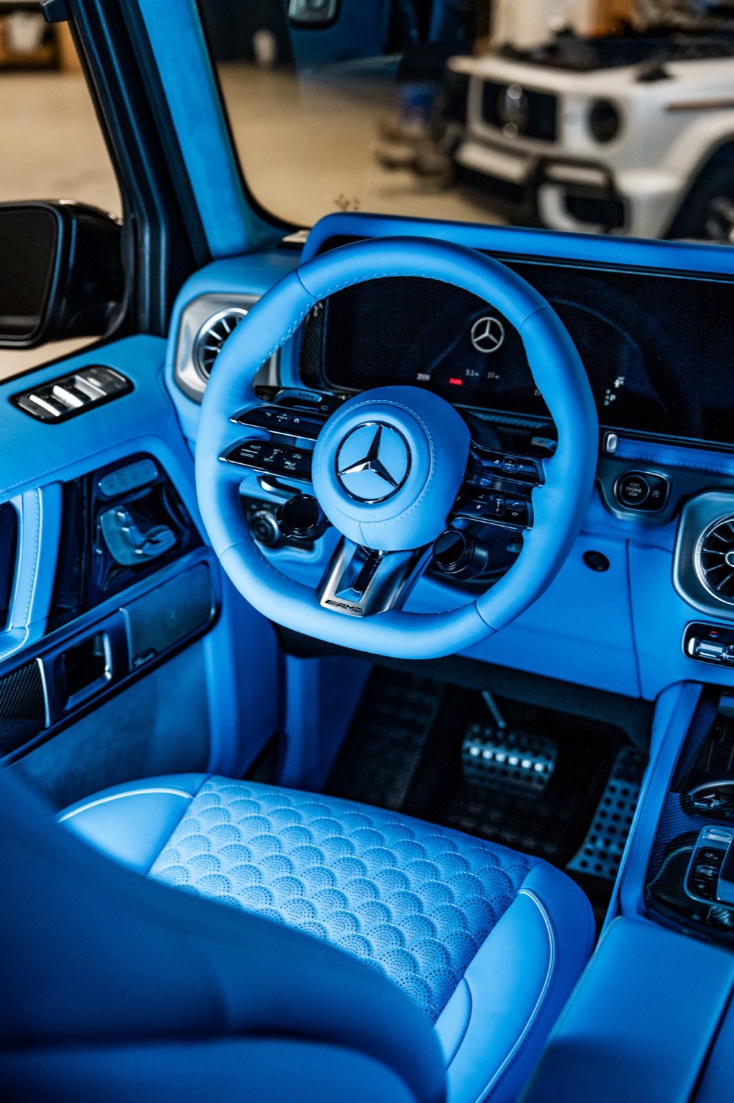 A sky blue steering wheel and the quilted driver seat