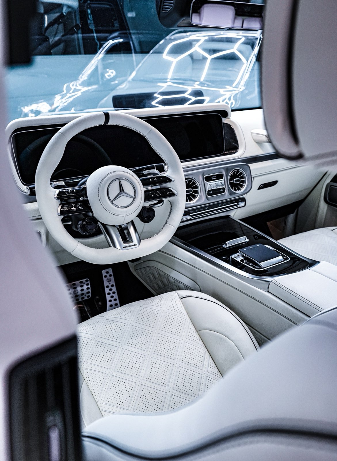 A G-Wagon cockpit with a white steering wheel and white seats