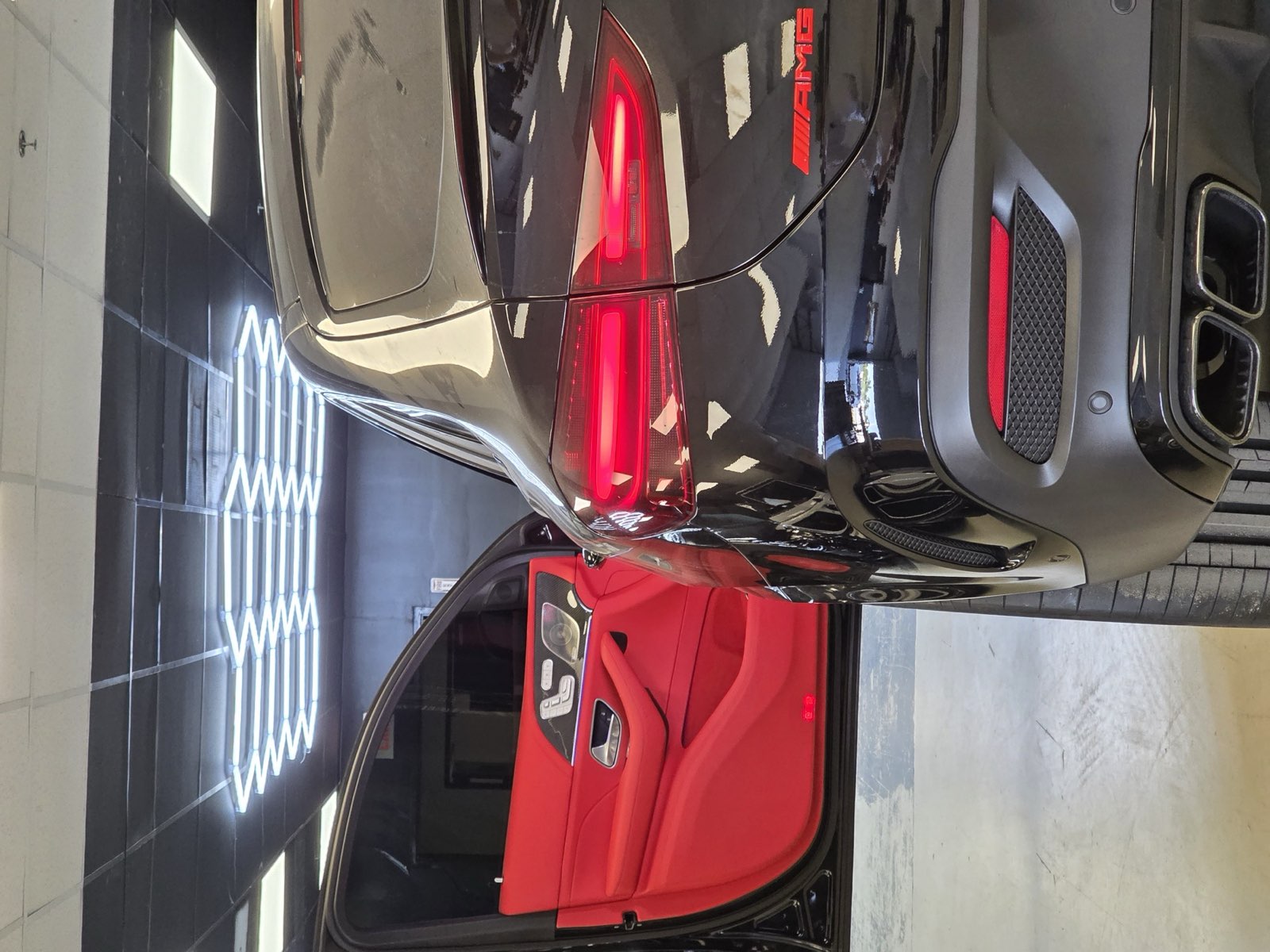 A black Mercedes GLE with the door open on a red cabin