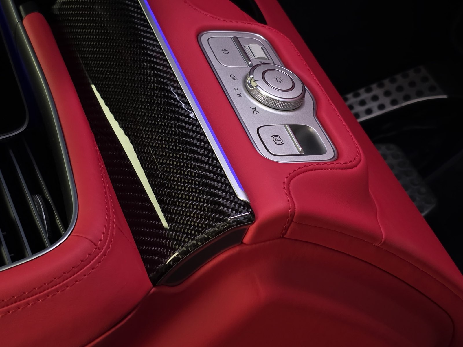 A red dashboard panel with carbon trim and switches
