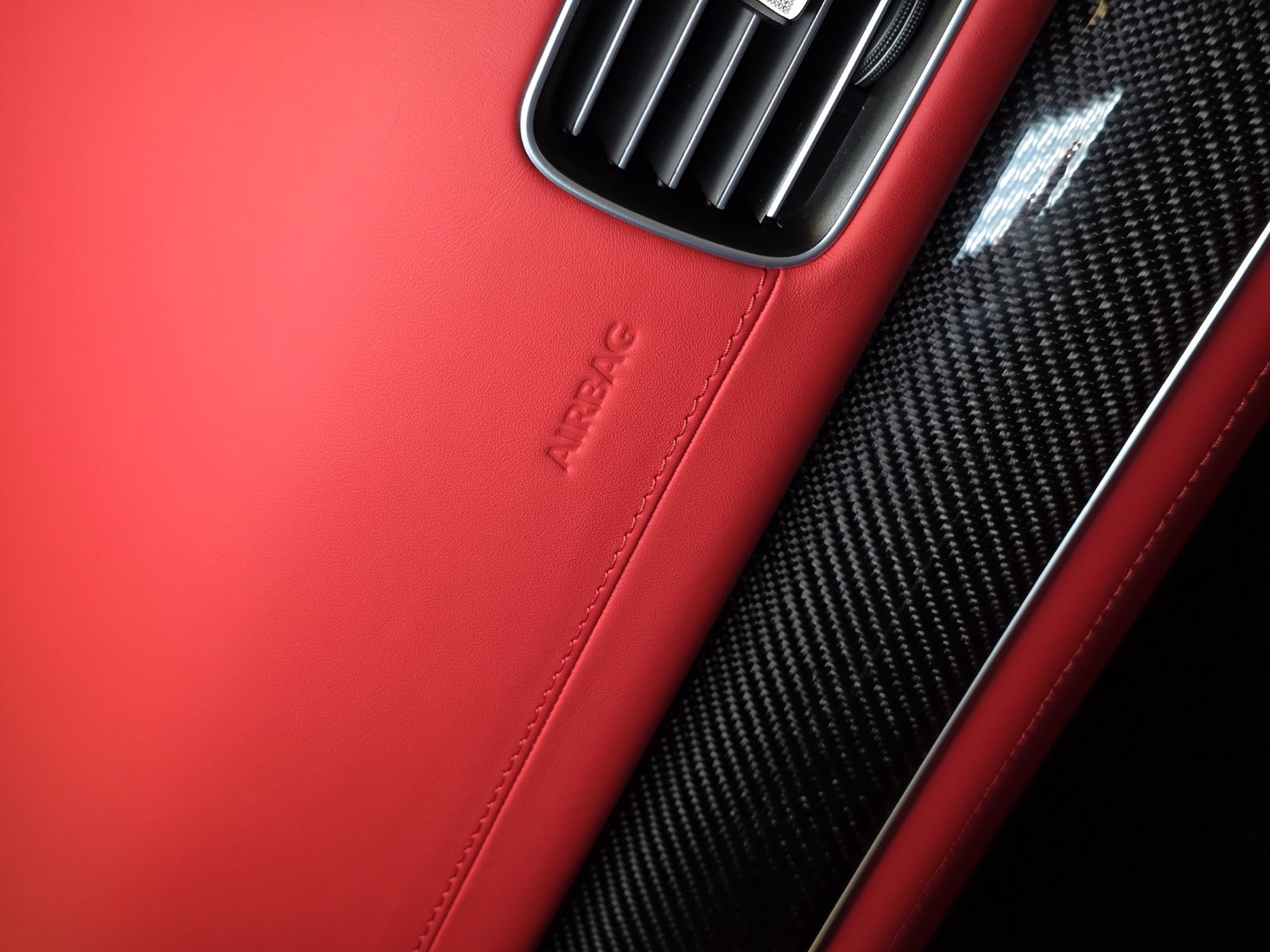 The red dashboard with the airbag mark and carbon trim
