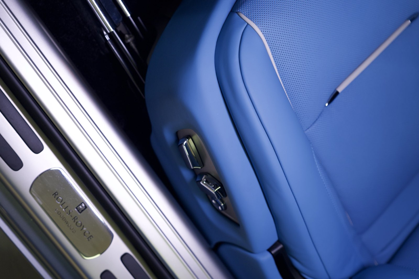 The side of a royal blue seat above the lit sill plate