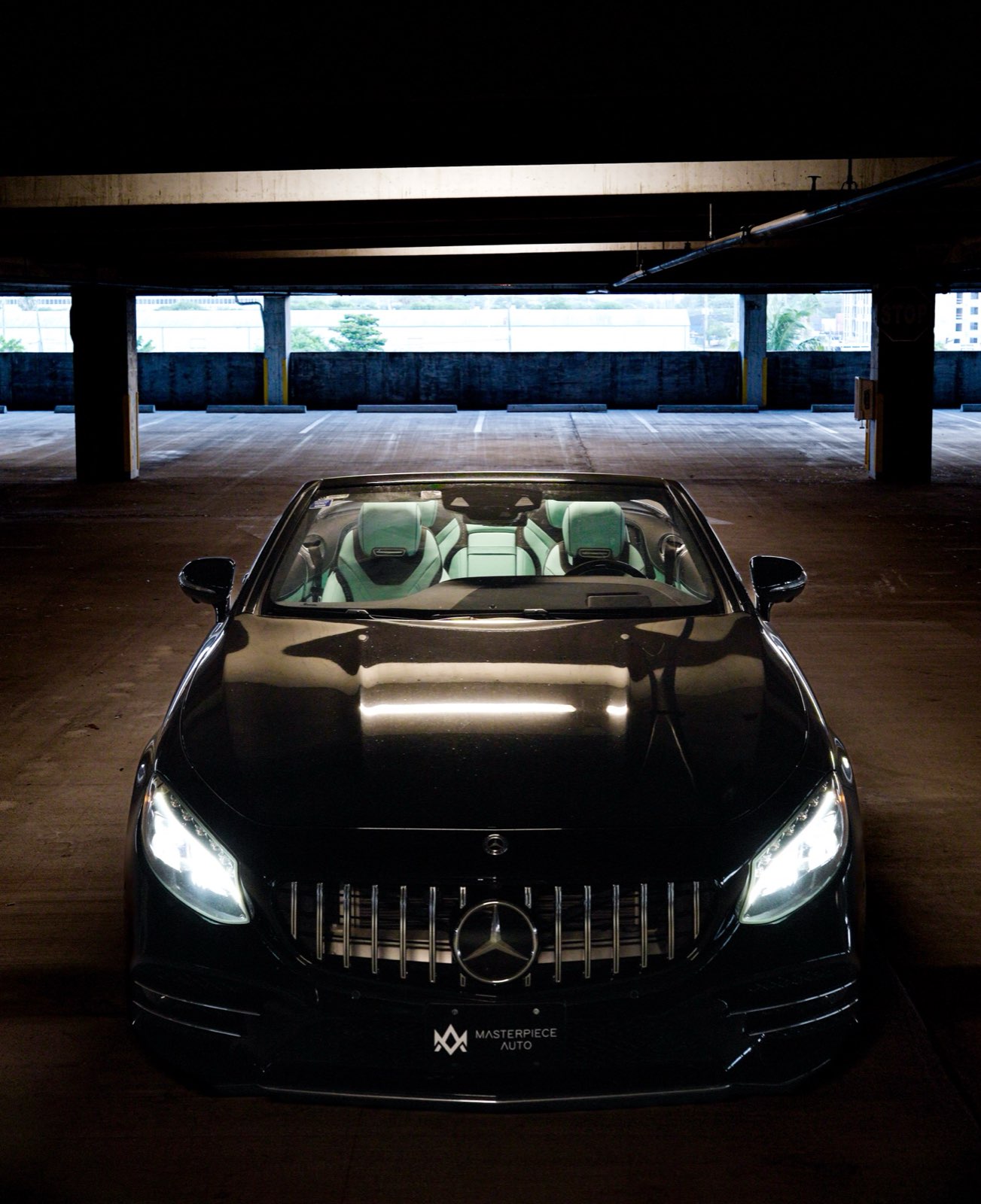 A black Mercedes S-Class convertible at night with the mint cabin inside