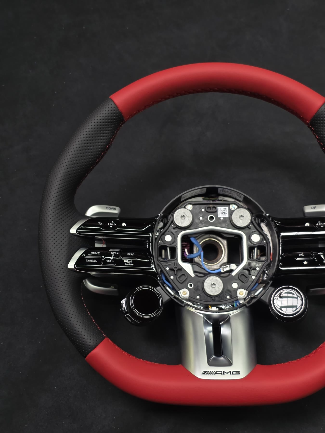 An AMG steering wheel with red top and bottom and black grips