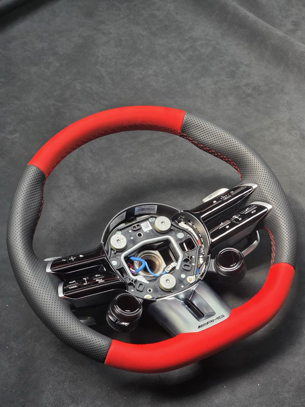 An AMG steering wheel rewrapped in red and black leather