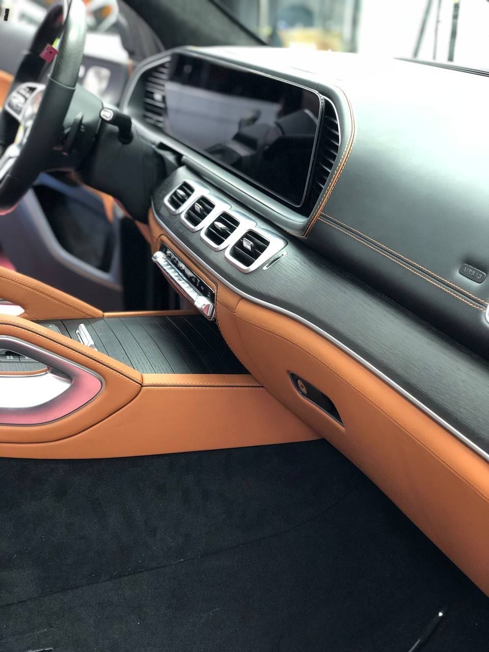 A dashboard in black leather over tan leather trim