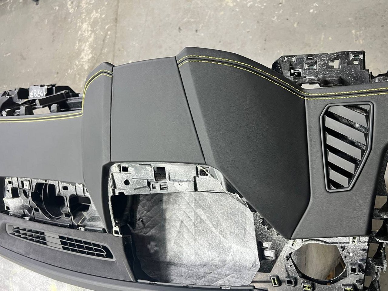 A Lamborghini Urus dashboard re-trimmed in black leather with yellow stitching, the centre and the passenger side