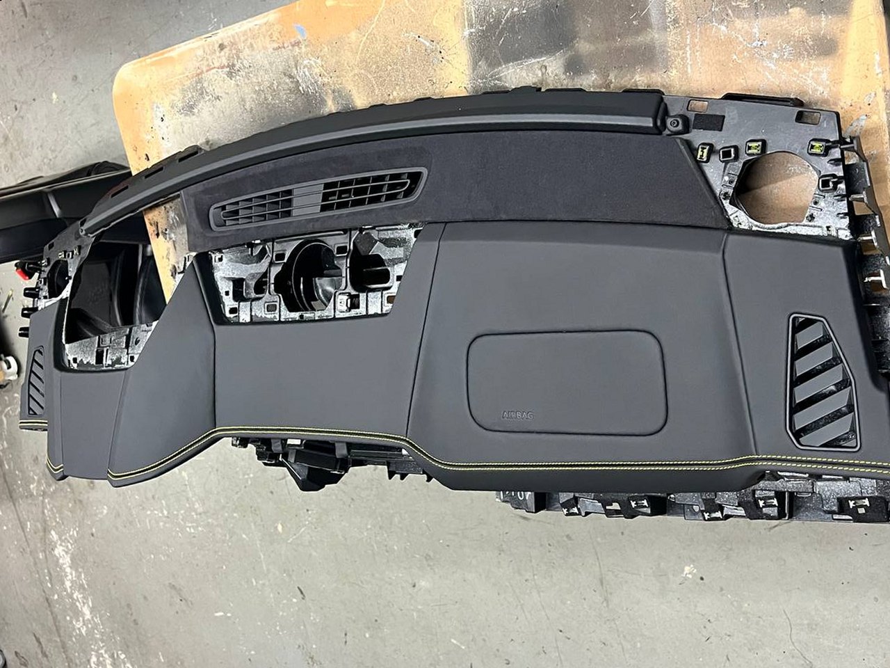 Lamborghini Urus dashboard: Black leather and a yellow double stitch, end to end, on the bench before it goes back in.