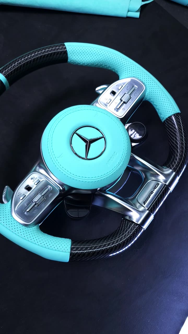 A carbon steering wheel with Tiffany blue leather grips and airbag cover